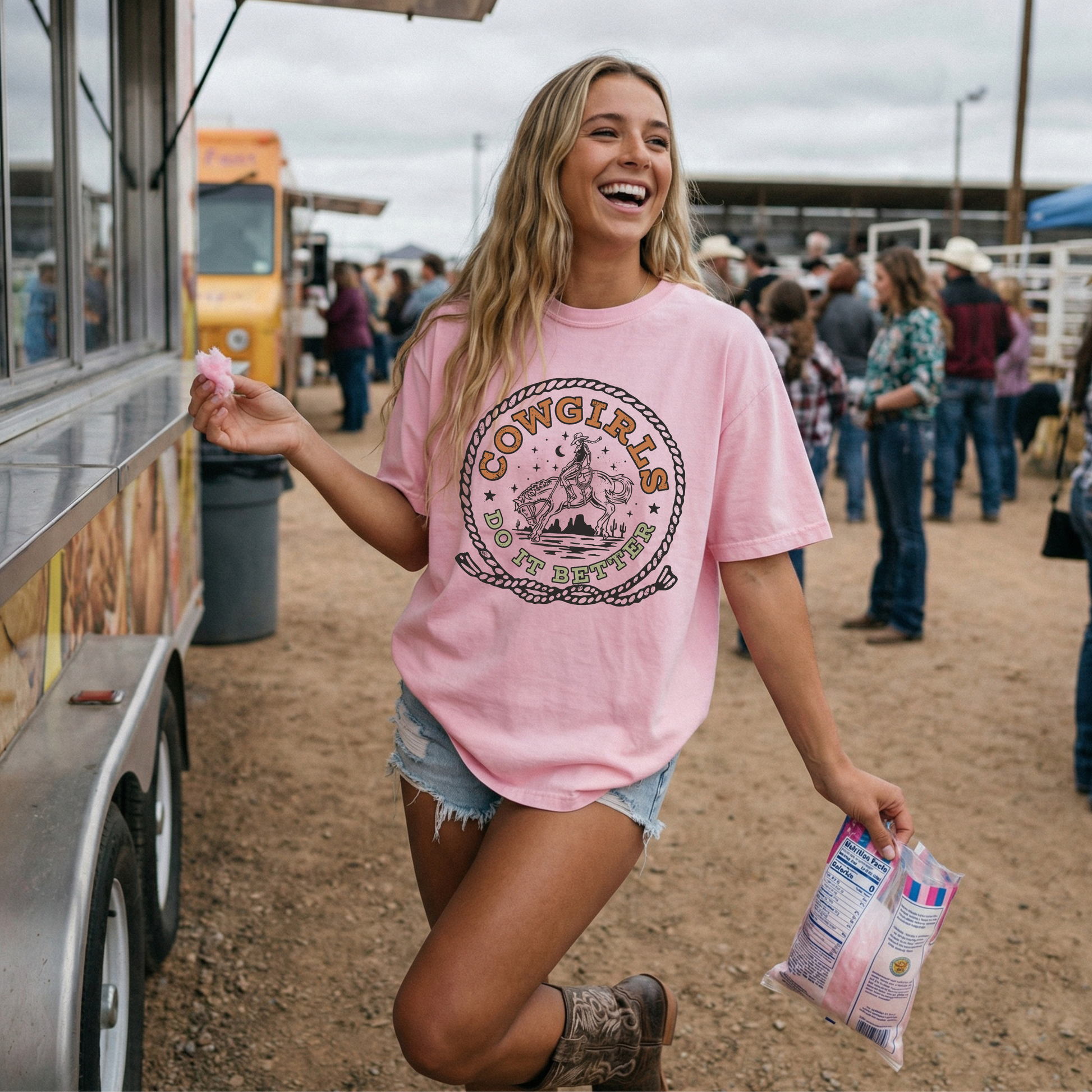 Woman wearing pink Cowgirls Do It Better Comfort Colors western graphic tee at a rodeo