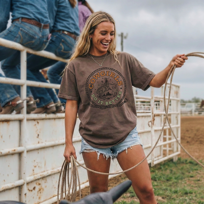 Cowgirl wearing Cowgirls Do It Better western tee with denim shorts and boots