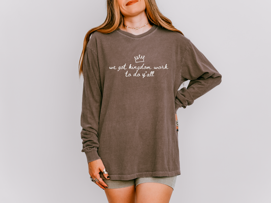 Person wearing a brown long-sleeve shirt with text on a plain background